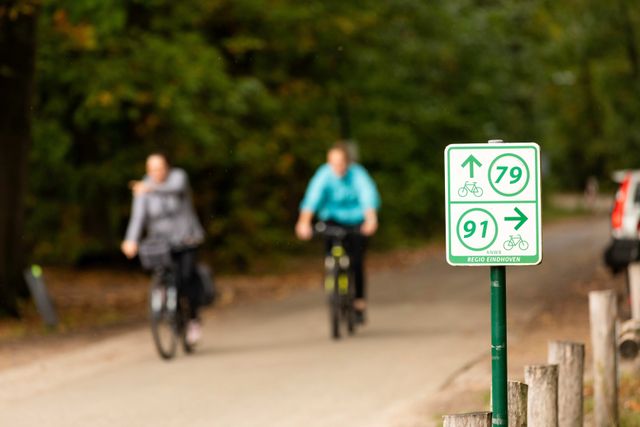 Fietsers fietsen richting fietsbordje