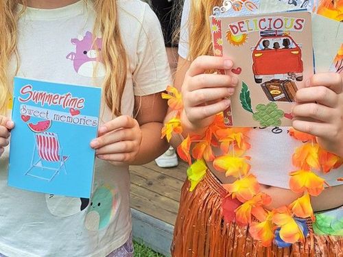 Twee meisjes die een zelfgemaakt boekje vasthouden