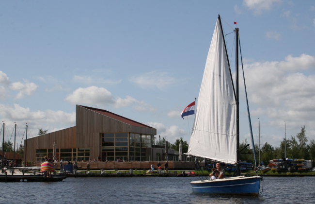 Een zeilboot vertrekt bij Cnossen en vaart het Leekstermeer op.