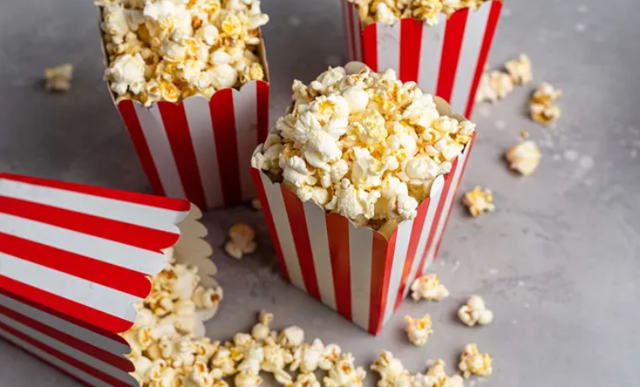 4 bakken met popcorn waarvan 1 is omgevallen.