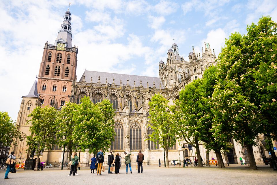 Parade met in de verte een groep mensen wijzend naar de kathedraal