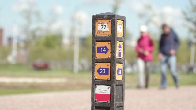 Een paal met diverse bordjes over wandelroutes.