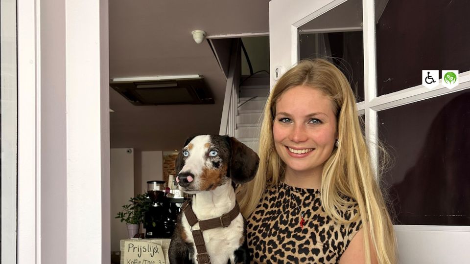 Eigenaresse van Het Roze Winkeltje in Woerden met hond in de deuropening, gezellige tweedehandswinkel in de binnenstad.