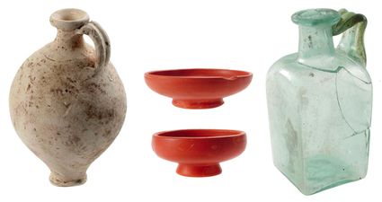 Enkele typisch Romeinse vondsten uit de crematiegraven: een gladwandige kruik, twee terra sigillata borden en een vierkante fles.