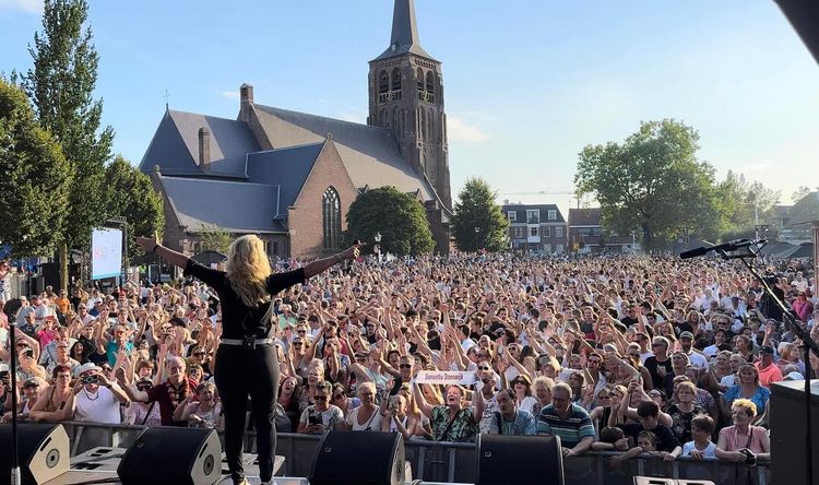 Het Sint Jansplein in Moergestel vol met zingende mensen tijdens een optreden van Samantha Steenbergen