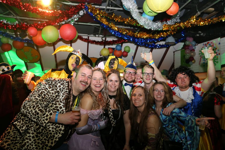 Carnavalsfeest met verklede volwassenen in feestzaal in Harmelen, Utrechtse regio, kleurrijke slingers en lampionnen tijdens een gezellige carnavalsavond met muziek en drinken.