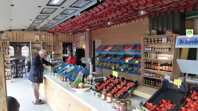 Landwinkel Kersenboomgaard en Boerderijwinkel De Ooievaar, Harmelen, provincie Utrecht, Groene Hart, interieur met vers fruit, groente, aardbeien, jam en streekproducten terwijl een klant afrekent bij de toonbank.
