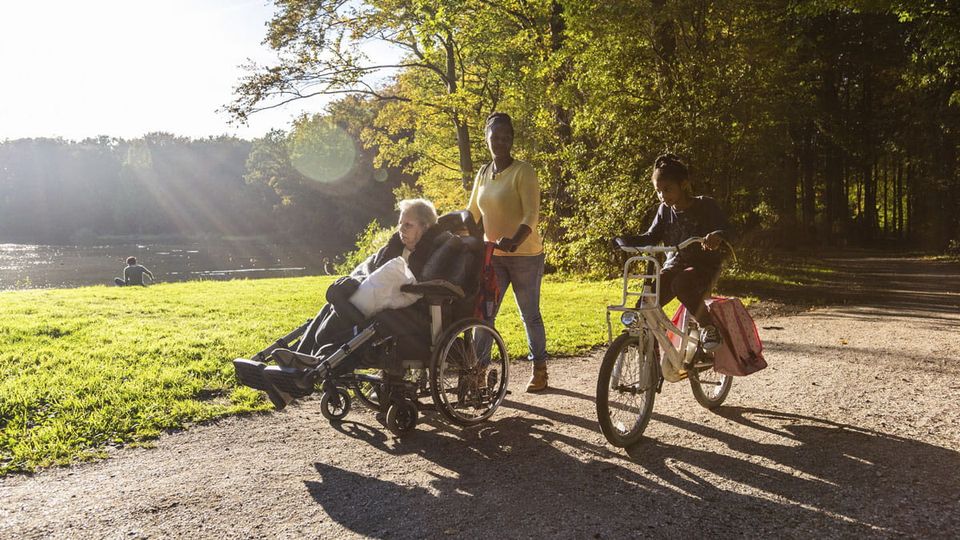 Wandelaars, waarvan eentje in een rolstoel, in de natuur