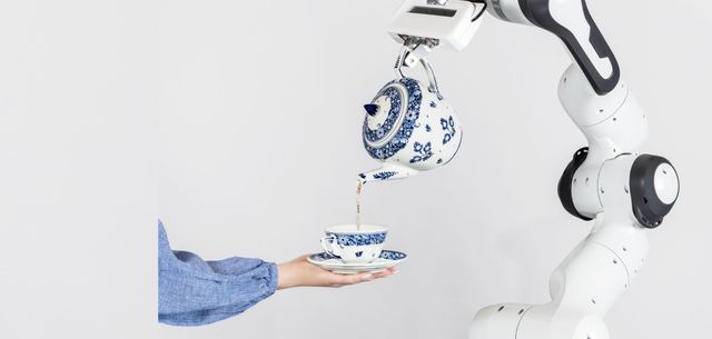 Robot die thee inschenkt in een mensenhand