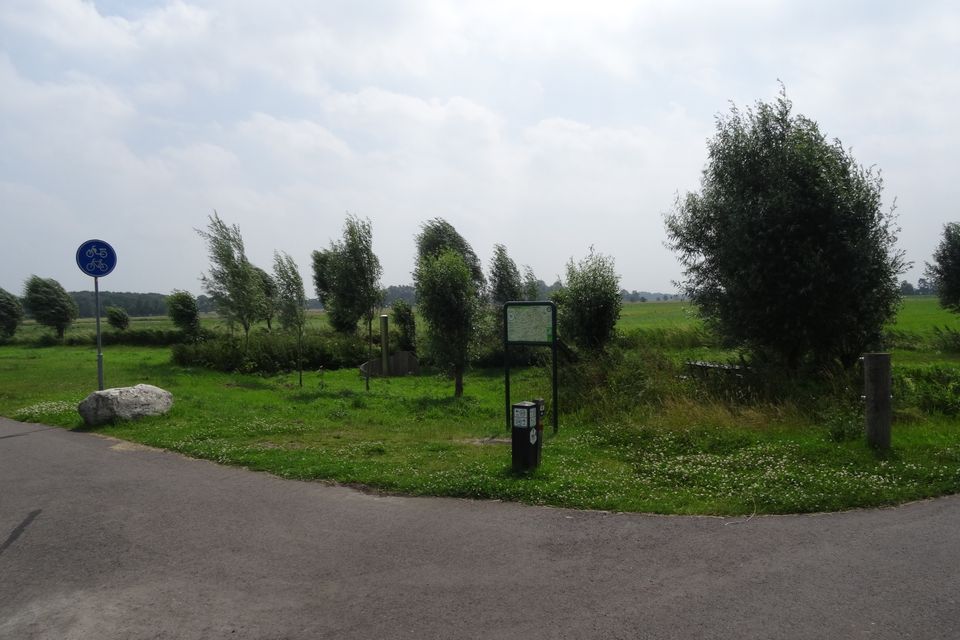 Een fietsknooppunt met knooppuntenbord en paaltjes.