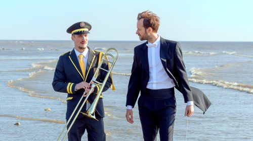Een muzikant en een man bij het strand