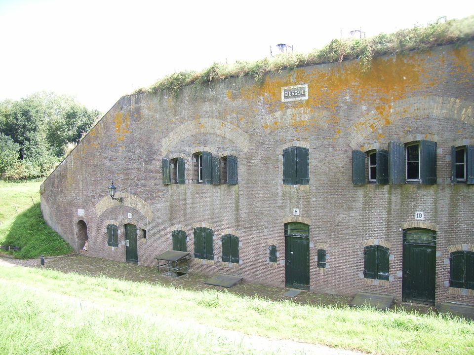 Een bakstenen fort overgroeid met mos en planten.