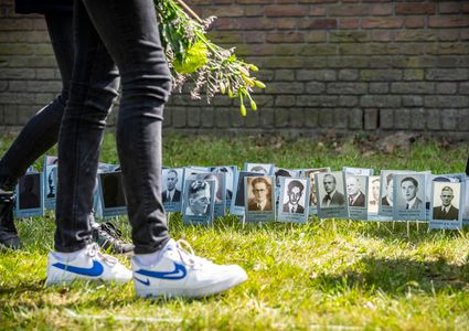Bezoekers plaatsen portretten van slachtoffers van Kamp Vught op 4 mei 2022
