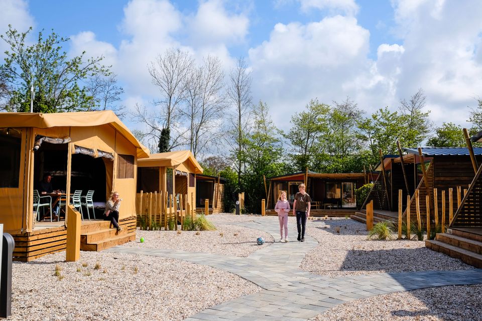 Sfeerfoto van vakantiegangers bij de luxe glampingtenten op Vakantiepark Koningshof in Rijnsburg.