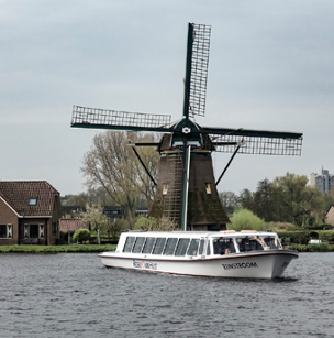 Boot in het water, met een molen op de achtergrond