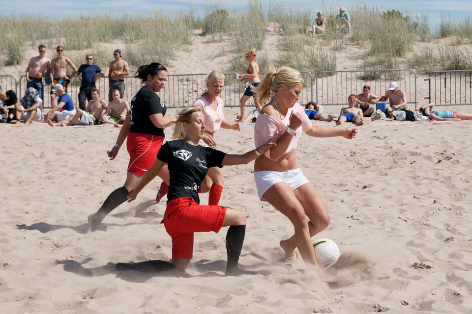 Mensen die aan het voetballen zijn op het strand
