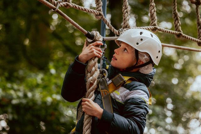 Jongetje, hangend aan een ziplijn in actie in het Klim- en Avonturenbos