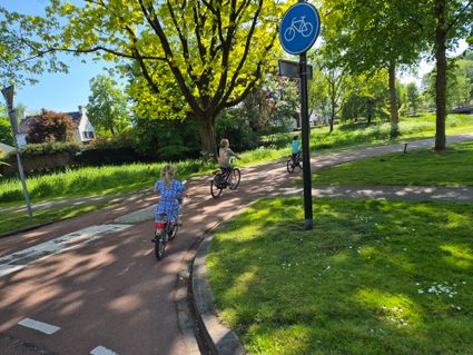 3 fietsende kinderen op fietspad door Oisterwijk