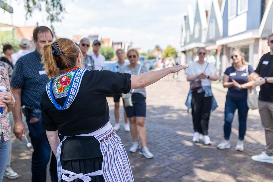 Een Volendamse gids die mensen rondleidt