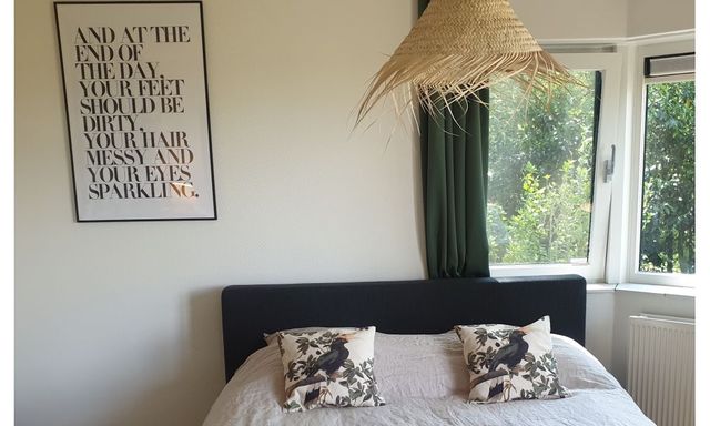 Vakantiehuis 'Boshuisje Doldersum' heeft een Swiss Sense bed met heerlijk bedlinnen en vanaf het bed kijk je zo de tuin in en de weide over