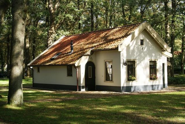 Ein gemütliches weißes Ferienhaus zwischen den Bäumen in Drenthe.