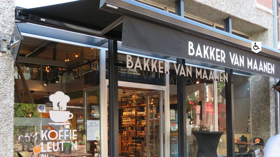Exterieur van Bakker Van Maanen in Woerden met terras en winkelpui, ambachtelijke bakkerij en koffiebar in het stadscentrum, plek voor vers brood, gebak en een koffiemoment tijdens een dagje Woerden.