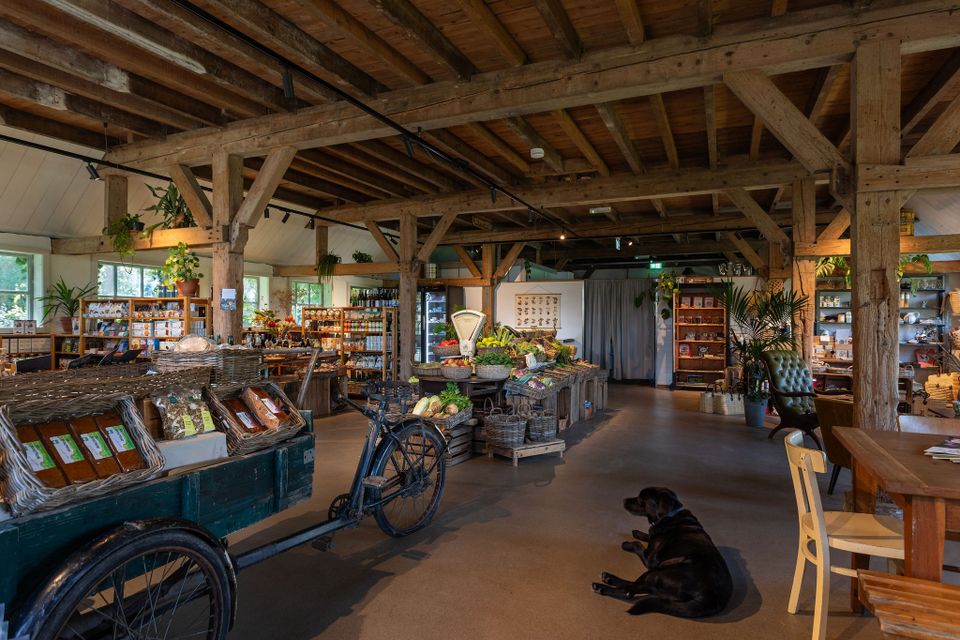 Landgoedwinkel Hof van Gunterstein in Breukelen, gemeente Stichtse Vecht, regio Utrecht. Ruime winkel in een houten boerderijschuur met streekproducten, kaarten, woonaccessoires en manden uitgestald tussen robuuste houten gebinten.