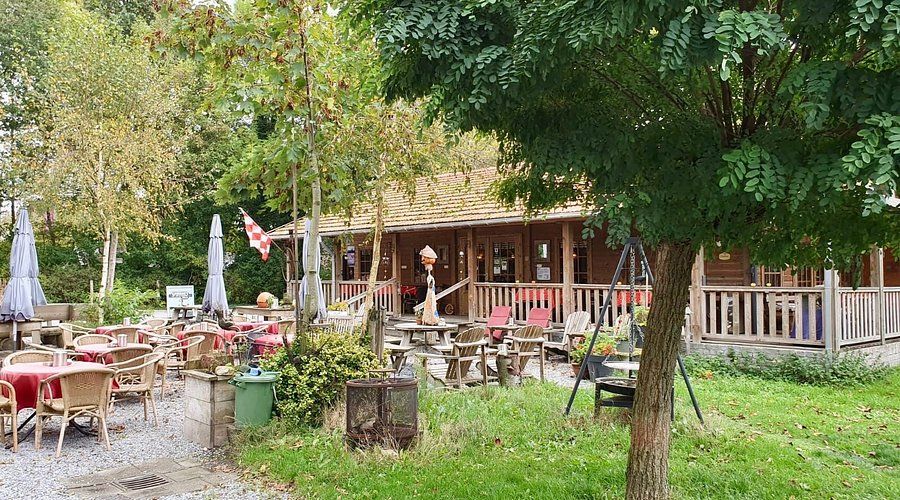 Het terras van De Stroom in het groen met houten meubilair