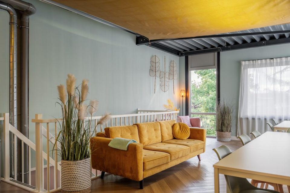 Een gekleurde ruimte met gele bank en een tafel.