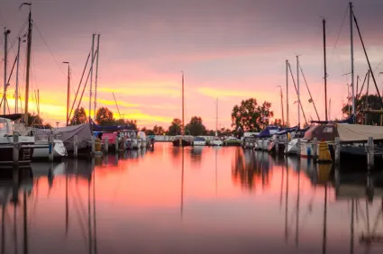Verschillende aangemeerde boten bij Jachthaven Drijfveer in Akkrum bij zonsondergang.