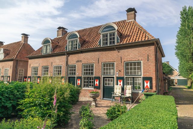 Karakteristieke historische woningen met rode pannendaken, groene luiken en verzorgde tuinen in Renswoude. De foto laat het monumentale en dorpse karakter van Renswoude zien.