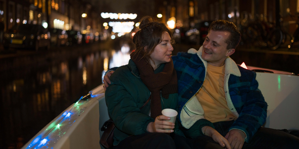 Een koppel in een bootje op de grachten van Delft in de avond