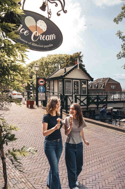 IJssalon Daan's Droomijs Montfoort, Groene Hart, bezoekers genieten van ambachtelijk ijs terwijl zij wandelen langs de historische ophaalbrug en de sfeervolle binnenstad.
