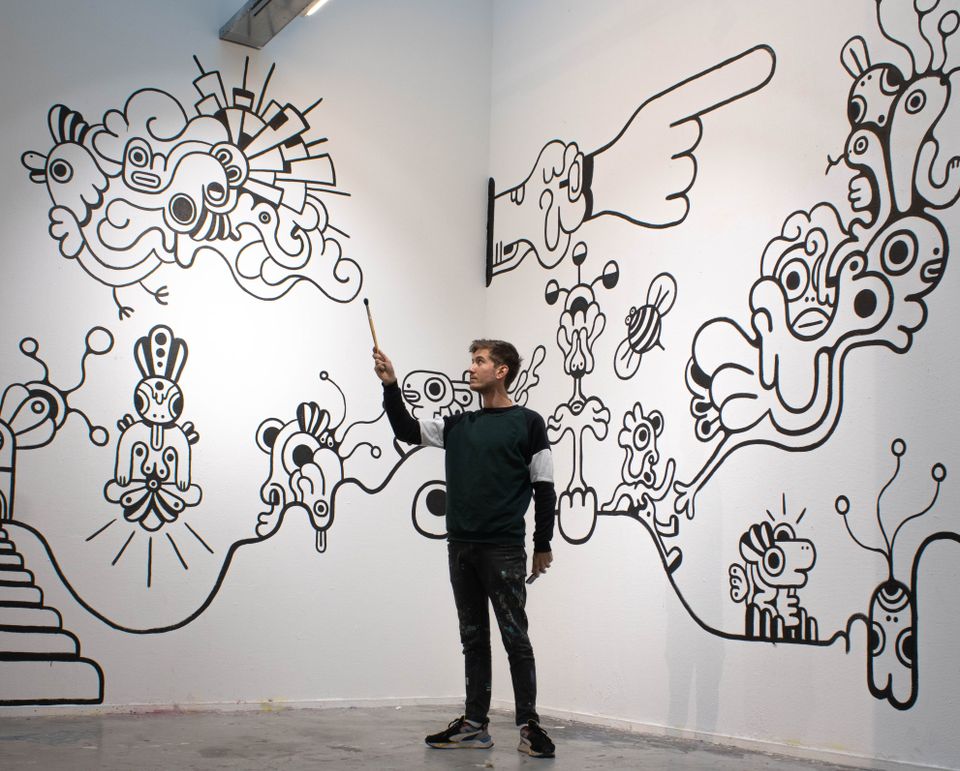 Man die een stok vasthoudt voor zwart-wit kunstwerk van lijnen in Kunstgarage Franx in Zoetermeer