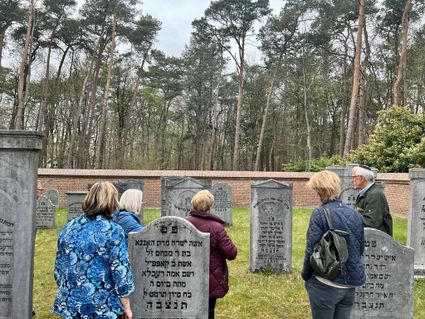 Bezoekers luisteren naar de toelichting van een gids tijdens een rondleiding over de Joods begraafplaats in Oisterwijk