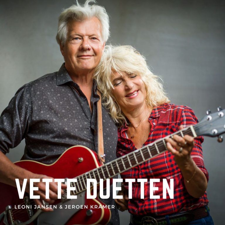 Een foto van een man en een vrouw met een gitaar