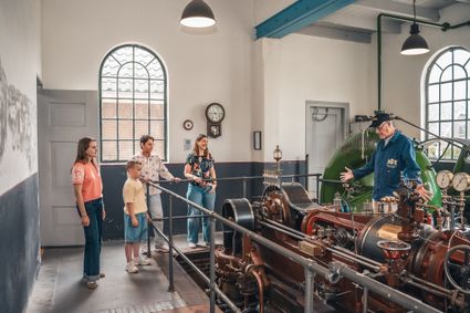Bezoekerscentrum Stoomgemaal Teijlingens in Kamerik, Groene Hart, rondleiding langs historische stoommachine waarbij een gids bezoekers uitleg geeft over het industriële erfgoed en de werking van het gemaal.