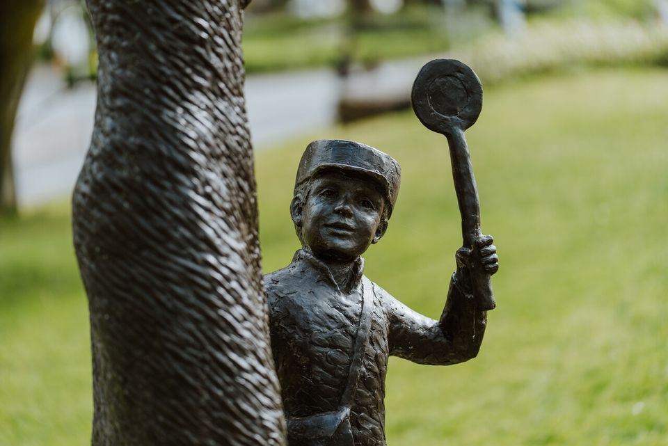 Statue of a mother and child waving.