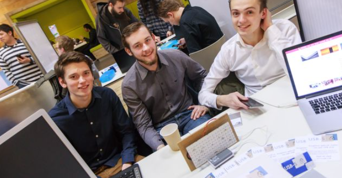 Drie mannelijke studenten aan een tafel.