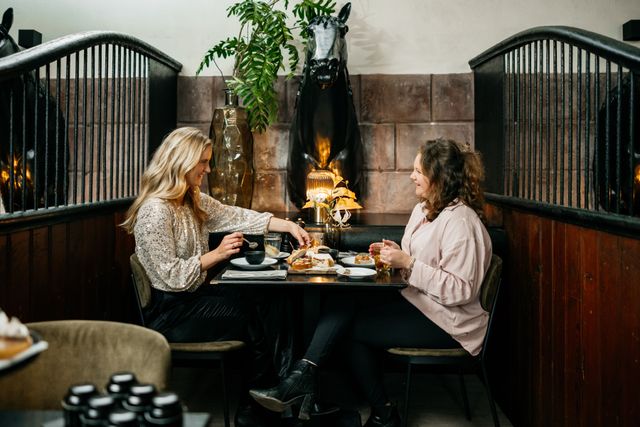 Twee vriendinnen genieten van een Diner in LIZ Restobar, waar de oude stallen zijn omgebouwd tot een sfeervol restaurant
