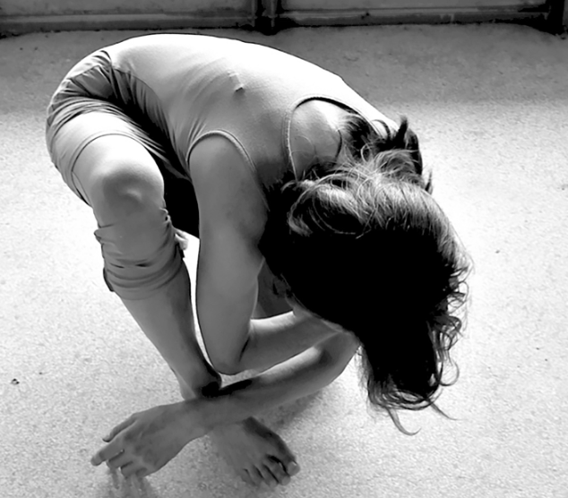 Zwart wit foto van ballerina die voorover gebogen zit