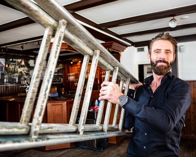 Een man die een ladder teelt in een café.