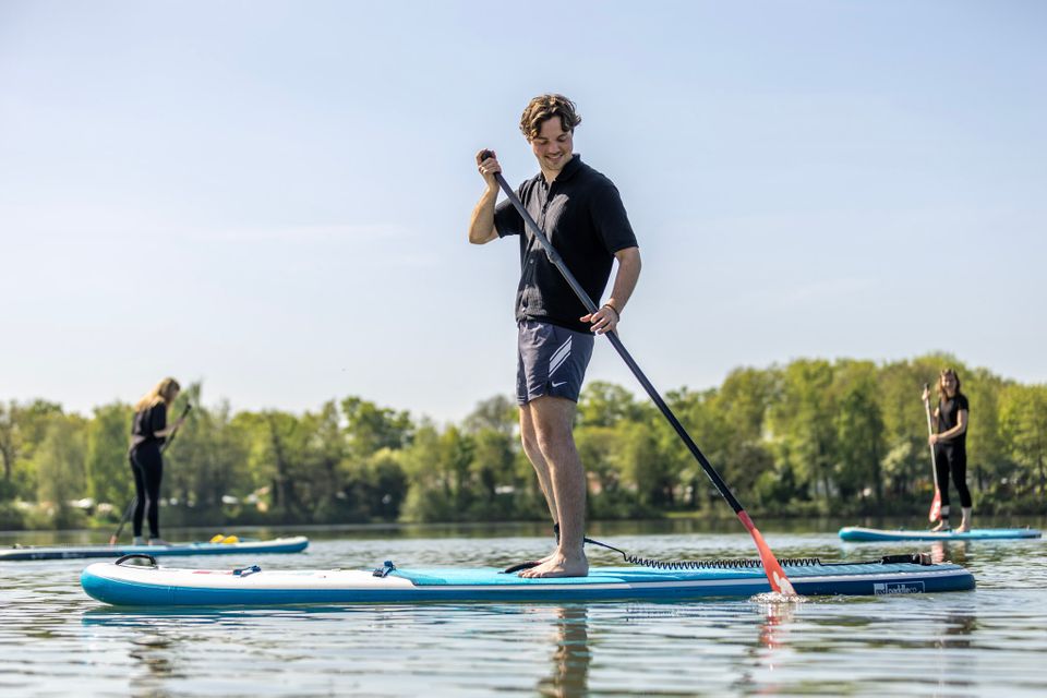 Jongen staat op een SUP.