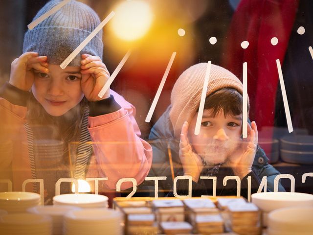 Twee kinderen die gluren door een etalage raam