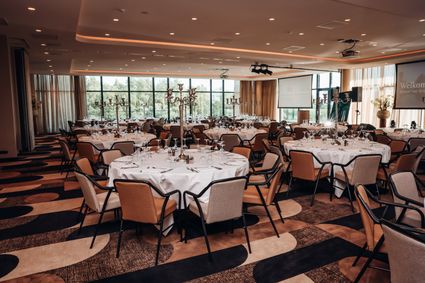 Evenementenlocatie Hotel Van der Valk Woerden, Woerden, Groene Hart, ruime en stijlvol ingerichte evenementenzaal met ronde tafels, gedekte couverts en presentatievoorzieningen voor zakelijke bijeenkomsten, congressen en diners.