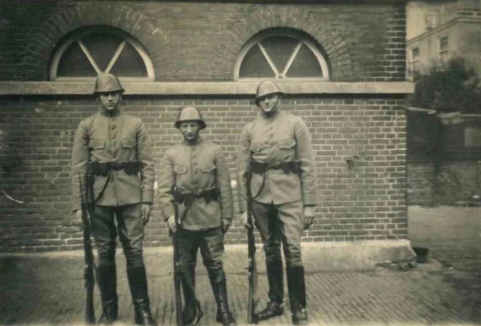 3 soldaten staan voor een muur