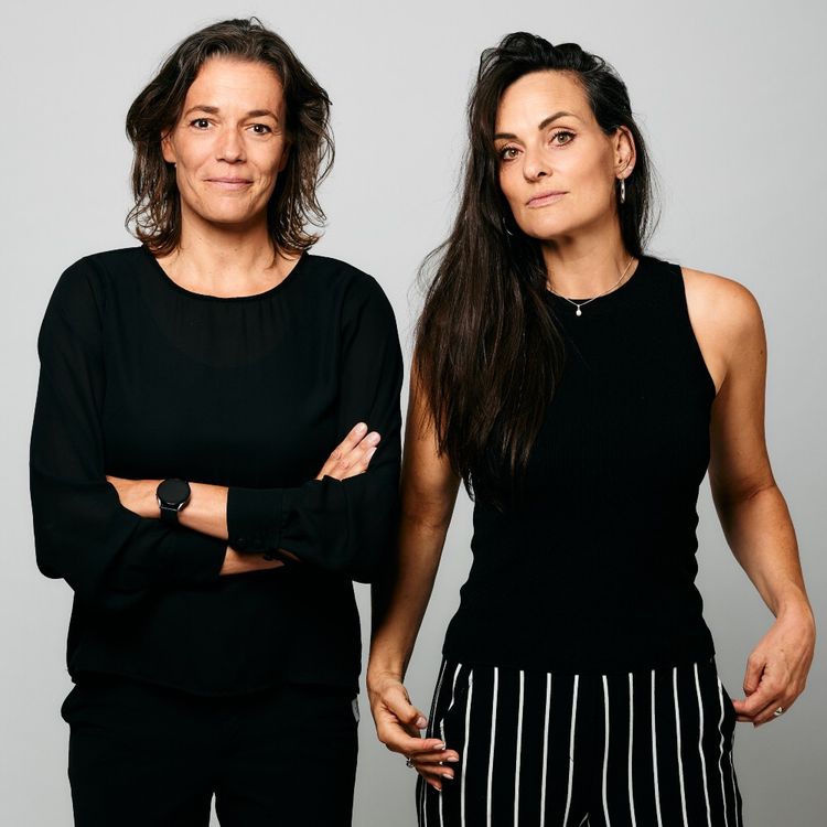Foto van Ilse en Marieke in zwarte kleding tegen een lichte achtergrond.