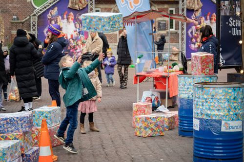 Kindje dat pakje in een schoorsteen gooit op het pietenbeweegplein
