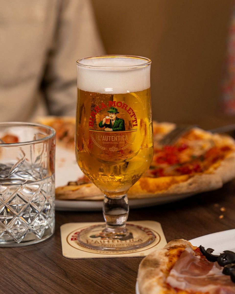Restaurant Voldaan in Oudewater, Groene Hart, glas Italiaans Birra Moretti bier op tafel met versgebakken pizza’s.