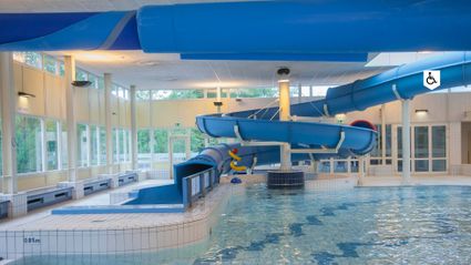 Zwembad Batenstein Woerden, provincie Utrecht, Groene Hart, modern overdekt recreatiebad met grote blauwe waterglijbaan, peuterbad en helder zwemwater voor een gezinsuitje.